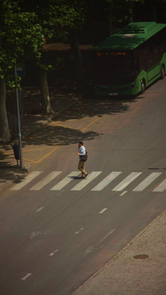 man walking across cross walk